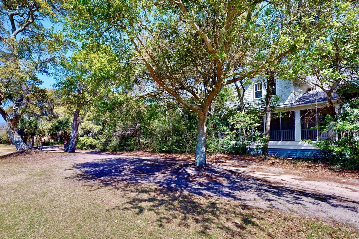 This serene exterior image features a house nestled among mature trees with a winding pathway leading up to it. The natural setting exudes tranquility, with a sense of adventure and outdoor exploration inviting guests to wander and enjoy the landscape. The visible pathway suggests easy outdoor access for both people and pets, making it ideal for strolling and play.